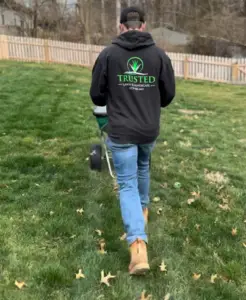 employee spreading granular fertilizer
