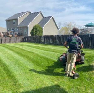 employee on lawn mower cutting grass